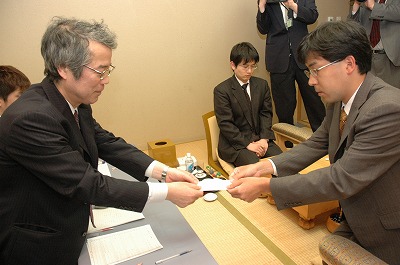 封じ手を立会人の二十四世本因坊秀芳に渡す羽根直樹本因坊